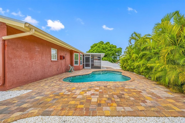 view of pool featuring a patio area and a sunroom