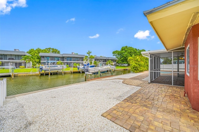 exterior space featuring a boat dock, a sunroom, and a water view