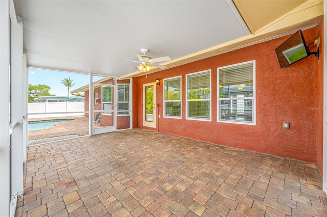 unfurnished sunroom with ceiling fan