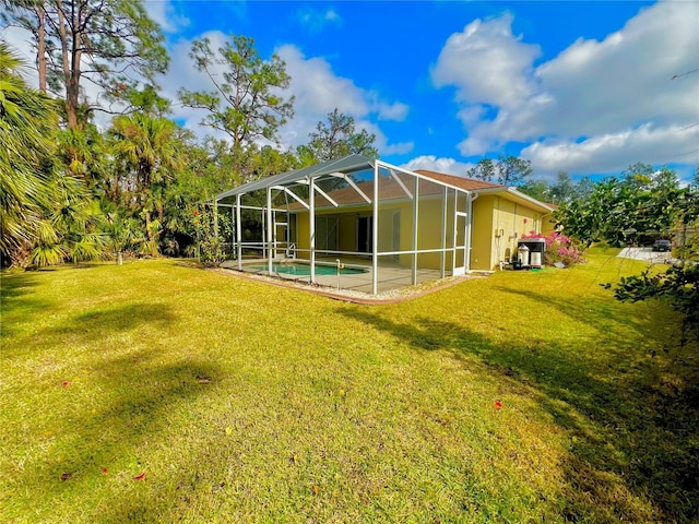 rear view of property featuring glass enclosure and a lawn