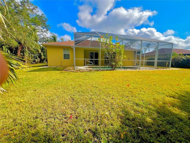 rear view of house featuring a patio area, a lanai, and a yard