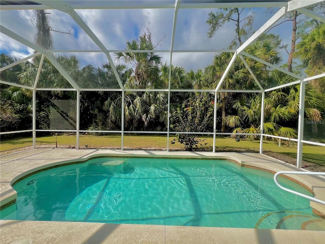 view of swimming pool with a patio, glass enclosure, and a lawn