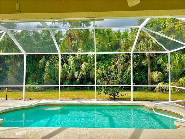 view of pool featuring ceiling fan, a patio, a lawn, and a lanai