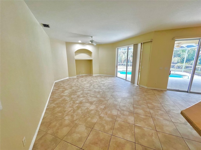 tiled spare room with ceiling fan