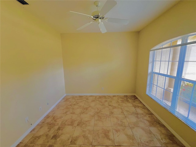 spare room featuring ceiling fan and light tile patterned flooring