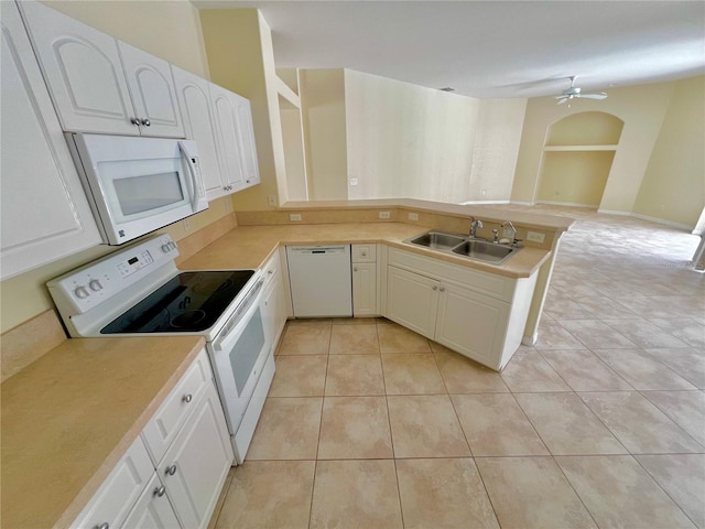 kitchen with kitchen peninsula, sink, white cabinetry, light tile patterned flooring, and white appliances