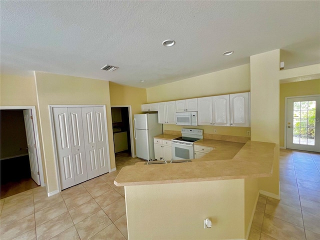 kitchen featuring kitchen peninsula, white appliances, white cabinets, and light tile patterned floors