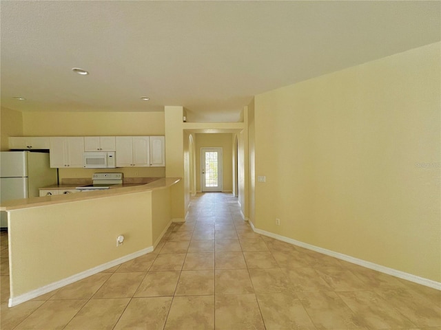 kitchen with white cabinets, white appliances, kitchen peninsula, and light tile patterned floors