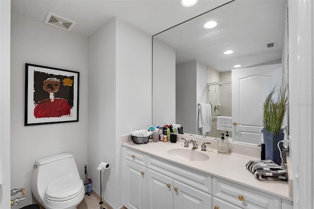 bathroom featuring tile patterned floors, vanity, toilet, and a shower with door