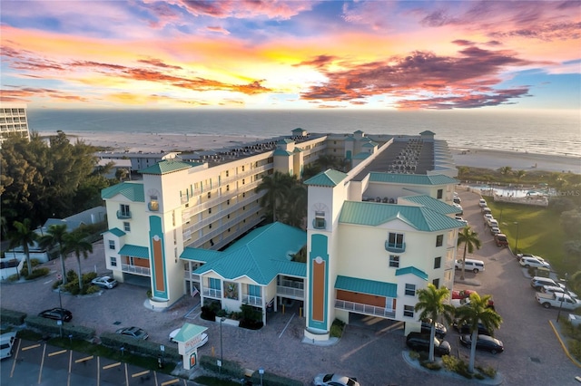 aerial view at dusk featuring a water view