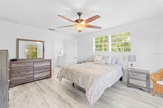 bedroom featuring ceiling fan, ensuite bath, and light hardwood / wood-style flooring