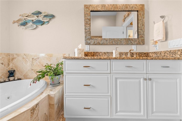 bathroom with a tub with jets and vanity