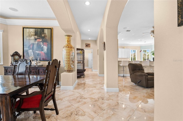 hallway featuring recessed lighting, ornamental molding, baseboards, and arched walkways