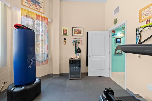workout room with beverage cooler, baseboards, and visible vents