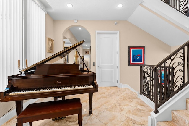 sitting room featuring recessed lighting, arched walkways, baseboards, and stairs