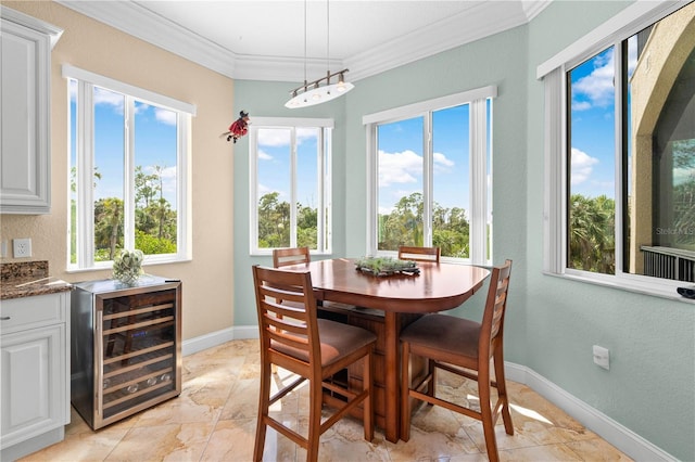 dining room featuring crown molding, a healthy amount of sunlight, marble finish floor, and wine cooler