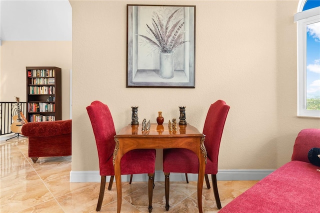 dining area with baseboards and marble finish floor