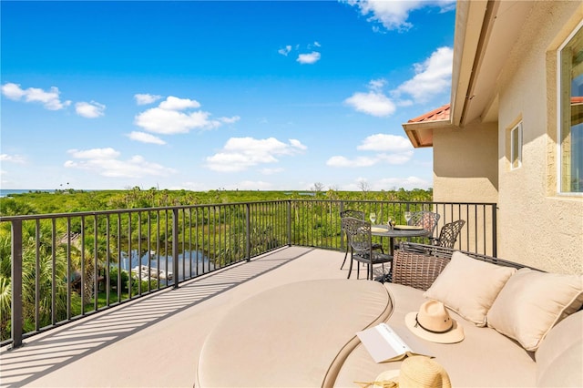 balcony featuring a water view and outdoor dining space