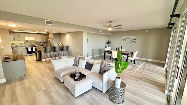 living room with ceiling fan and light wood-type flooring