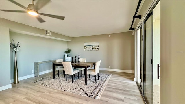 dining space with ceiling fan and light wood-type flooring