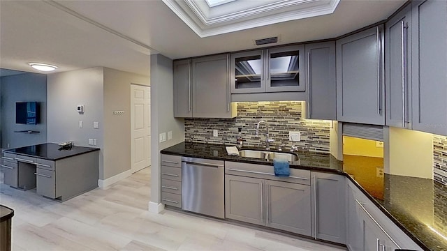 kitchen featuring sink, crown molding, backsplash, stainless steel dishwasher, and dark stone counters