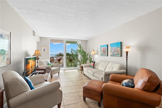 tiled living room with floor to ceiling windows and a textured ceiling