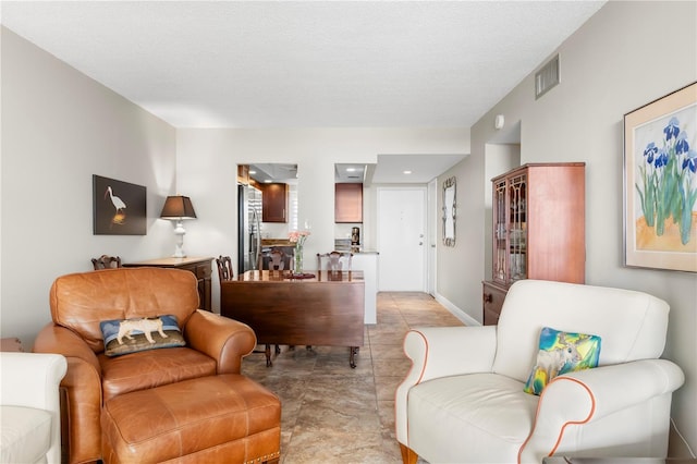 tiled living room featuring a textured ceiling