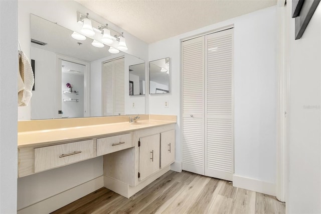 bathroom with vanity, hardwood / wood-style floors, and a textured ceiling