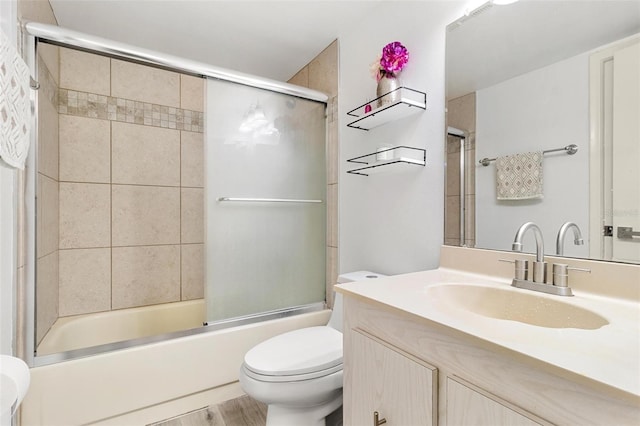 full bathroom with enclosed tub / shower combo, vanity, hardwood / wood-style floors, and toilet