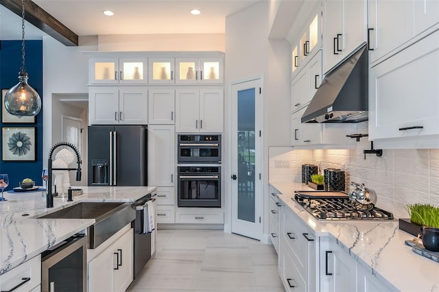 kitchen featuring stainless steel gas stovetop, decorative light fixtures, beam ceiling, black fridge with ice dispenser, and white cabinetry