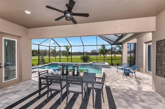 view of patio / terrace featuring a lanai, ceiling fan, and a pool with hot tub