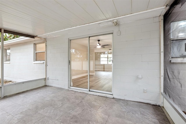 unfurnished sunroom with ceiling fan