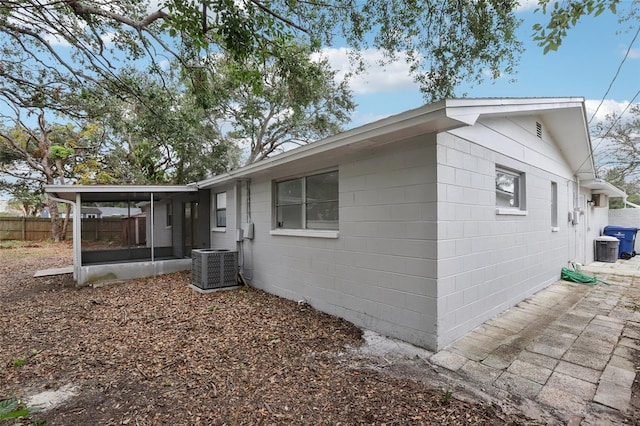 view of property exterior featuring central AC and a sunroom