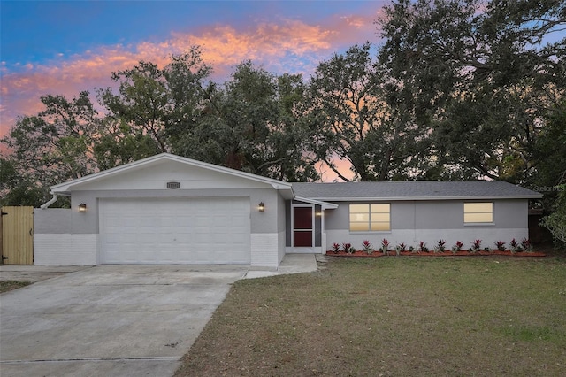 single story home with a garage and a lawn