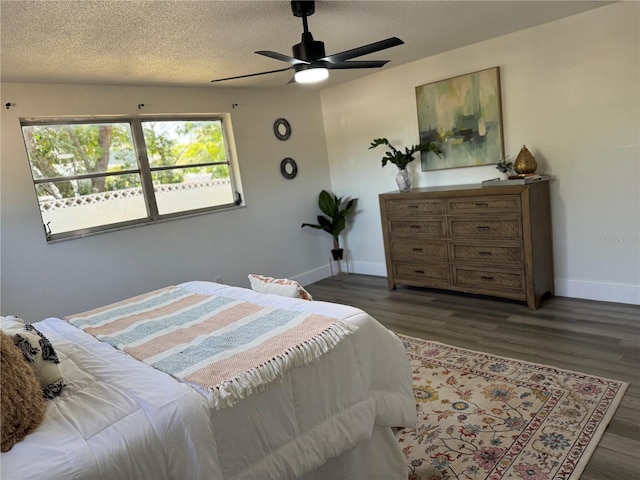 bedroom with baseboards, a ceiling fan, a textured ceiling, and wood finished floors