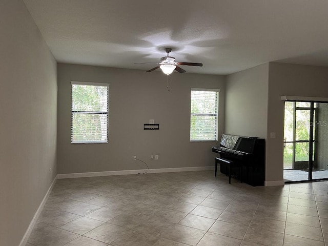 empty room featuring light tile patterned flooring and ceiling fan