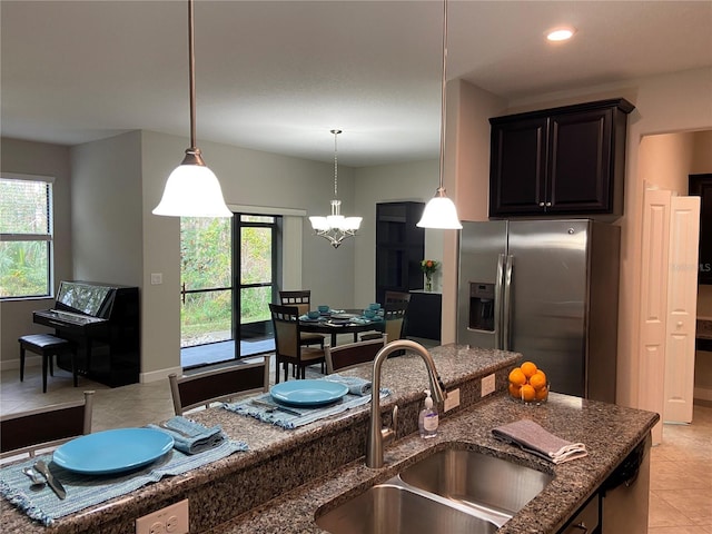 kitchen with stainless steel refrigerator with ice dispenser, a healthy amount of sunlight, decorative light fixtures, and sink