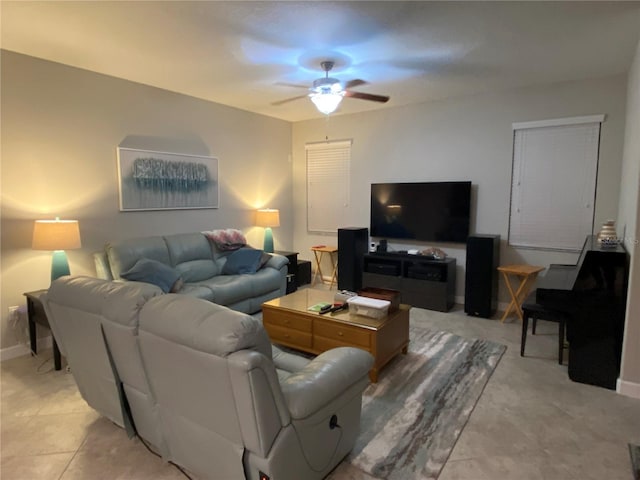 living room with light tile patterned floors, baseboards, and ceiling fan