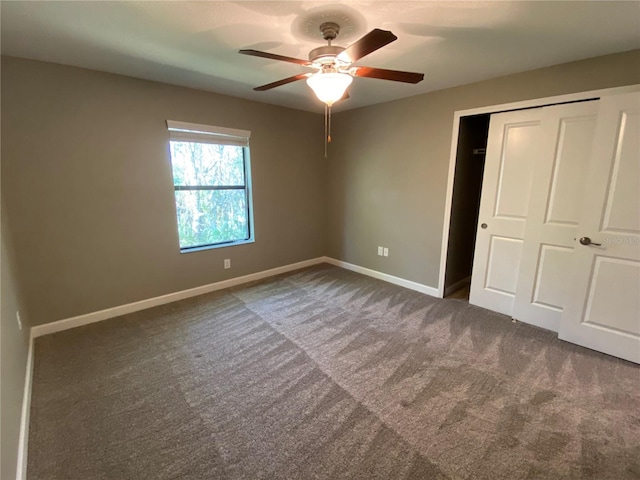 unfurnished bedroom with ceiling fan, a closet, and dark colored carpet