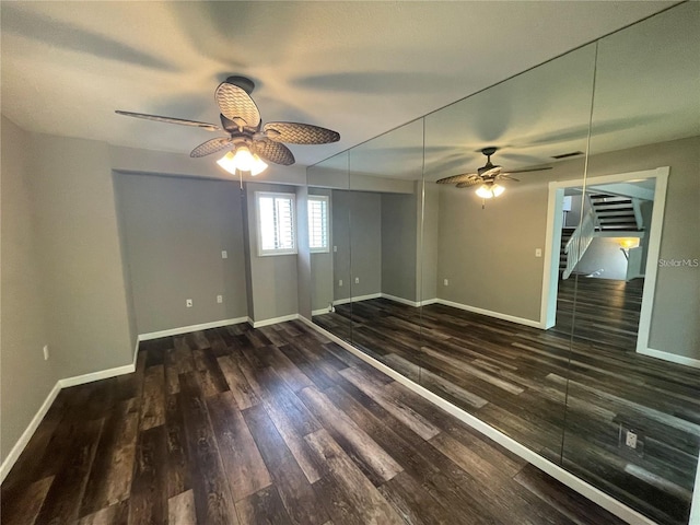 empty room with ceiling fan and dark wood-type flooring