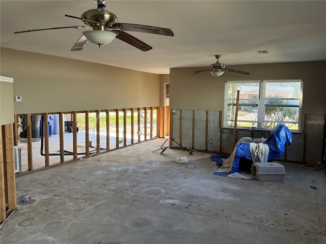 spare room with ceiling fan and concrete floors