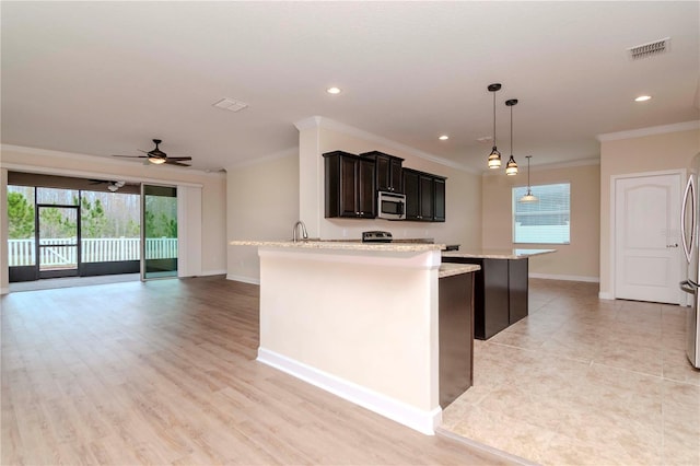 kitchen with ornamental molding, ceiling fan, a healthy amount of sunlight, and hanging light fixtures