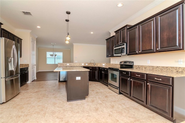 kitchen featuring a kitchen bar, hanging light fixtures, appliances with stainless steel finishes, and dark brown cabinets