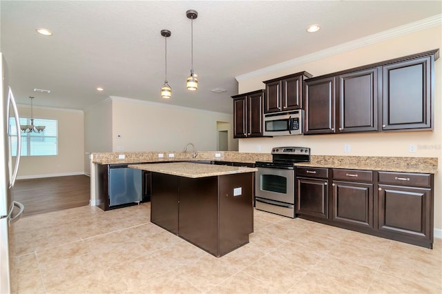 kitchen with an inviting chandelier, stainless steel appliances, a kitchen island, pendant lighting, and dark brown cabinetry