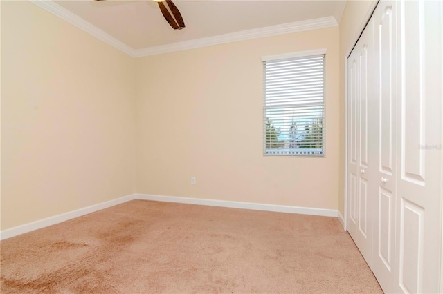 unfurnished bedroom with ceiling fan, light colored carpet, a closet, and ornamental molding