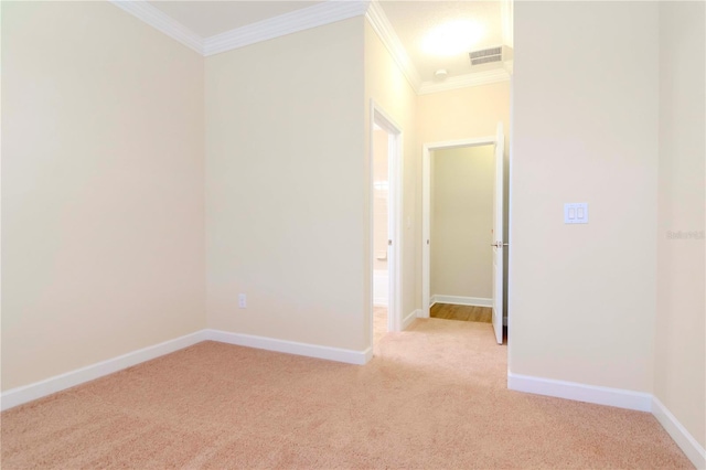 spare room with light carpet and crown molding