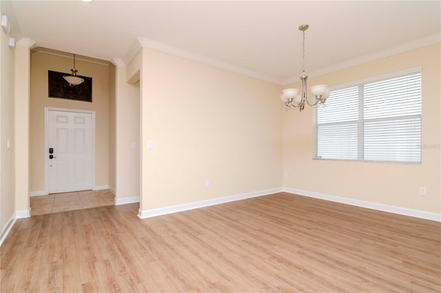 unfurnished room with an inviting chandelier, ornamental molding, and light hardwood / wood-style floors