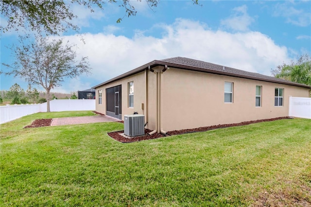 view of home's exterior featuring a patio area, central AC unit, and a yard