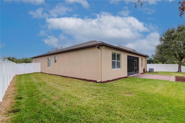 back of house featuring central air condition unit, a lawn, and a patio