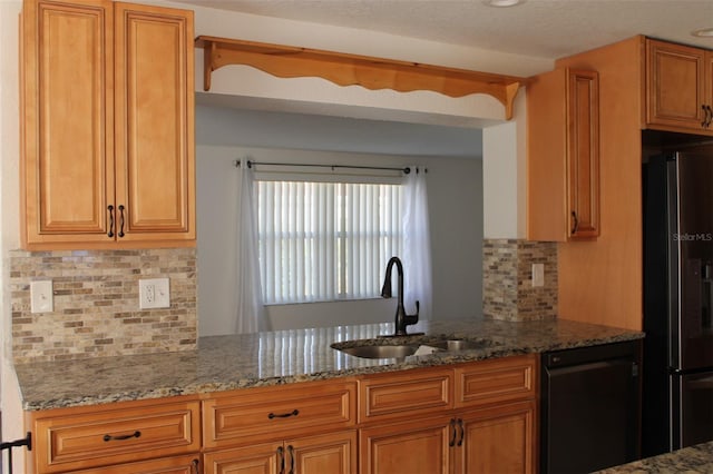 kitchen featuring backsplash, fridge with ice dispenser, dishwasher, and sink